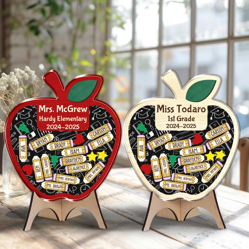 May include: Two apple-shaped wooden teacher appreciation gifts. One is red, the other is natural wood. Both have a black chalkboard design with student names and the text "Mrs. McGrew Hardy Elementary 2024-2025" and "Miss Todaro 1st Grade 2024-2025".