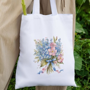 May include: White tote bag with a watercolor illustration of a bouquet of blue forget-me-not flowers and pink roses tied with blue and pink ribbons.