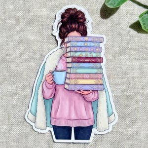 Könnte beinhalten: Ein Aufkleber mit der Illustration einer Person mit braunem Dutt, die einen rosa Pullover und einen hellblauen Mantel mit weißem Fellbesatz trägt. Die Person hält einen Stapel aus neun bunten Büchern und eine hellblaue Kaffeetasse vor das Gesicht.