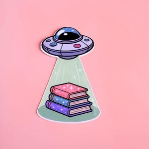 Pegatina de libro OVNI: vinilo de fantasía literaria con abducción extraterrestre para lectores, portátiles, botellas de agua, diarios, Kindle y regalo para amantes de la lectura.