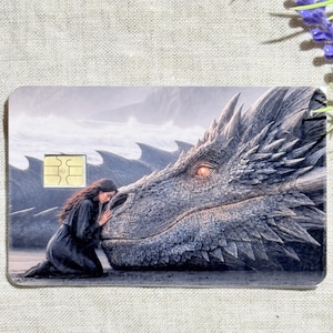 a debit card skin of a black dragon laying it's head down so a small woman may rest her head on his nose.
thestickerera