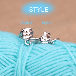 May include: Two silver Halloween-themed rings. One ring features a jack-o'-lantern design, and the other has a jack-o'-lantern wearing a witch's hat. The word "STYLE" is at the top of the image, with "Style2" and "Style1" below it.