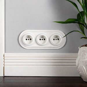 May include: A set of three ceramic mugs with a speckled, matte finish in cream, light grey, and dark grey. Each mug has a simple, minimalist design, suitable for coffee or tea.