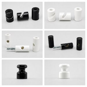 May include: A selection of black and white ceramic insulators and cable guides. The insulators are cylindrical with a rounded top and bottom. Some have a groove or hole for cable passage. The cable guides are cylindrical with a slot for the cable.