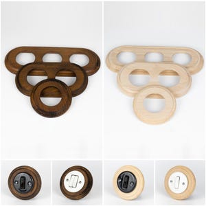 Puede incluir: Placas de interruptores de luz y cubiertas de enchufes de madera en varios estilos. La imagen muestra acabados de madera marrón oscuro y natural. Las placas tienen formas ovaladas y circulares con agujeros. Las cubiertas de los enchufes son redondas con interruptores negros o blancos.