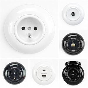 Könnte beinhalten: Eine Sammlung weißer und schwarzer Steckdosen und Anschlüsse. Die weißen Steckdosen umfassen eine europäische Standardsteckdose, einen Koaxialkabelanschluss sowie einen USB-C- und USB-A-Ladeanschluss. Die schwarzen Steckdosen umfassen eine europäische Standardsteckdose und einen Ethernet-Anschluss.