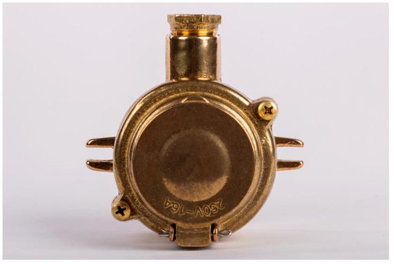May include: A brass electrical component with a circular body and a cylindrical top. The component has two small, horizontal protrusions and is secured with screws. The text "250V-16A" is visible on the front.