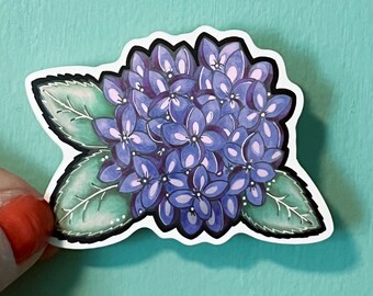 Puede incluir: Una pegatina con una flor de hortensia morada y verde con un contorno blanco.