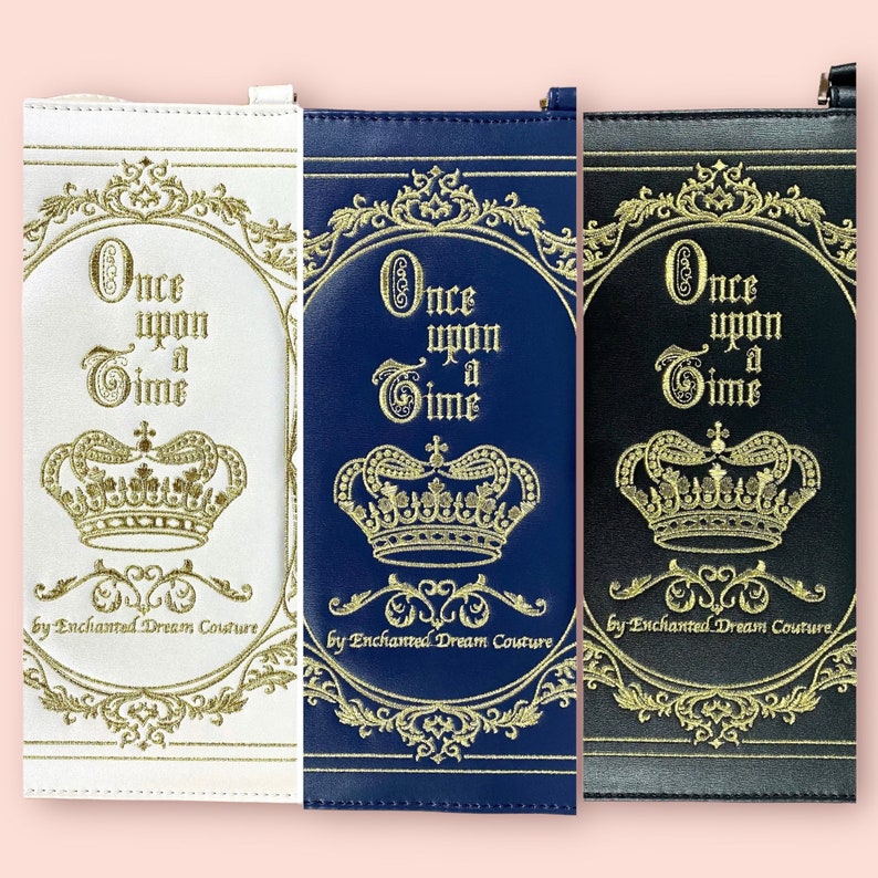 May include: Three different colored zippered pouches with a gold embroidered design. The pouches feature a crown and the text "Once upon a Time" with the words "by Enchanted Dream Couture" at the bottom.