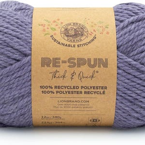 May include: A ball of Re-Spun yarn in a muted purple hue. The label reads "Thick & Quick" and "100% Recycled Polyester." The yarn weighs 12 oz and is 223 yards long. Ideal for knitting and crochet projects.