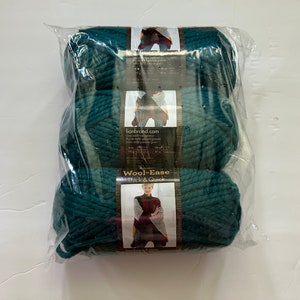 May include: Three skeins of teal blue Wool-Ease Thick & Quick yarn by Lion Brand. The yarn is packaged in a clear plastic bag with a label that says "Wool-Ease Thick & Quick" and "lionbrand.com".