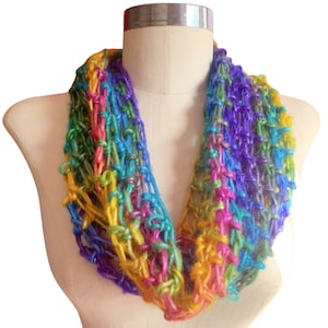 May include: A colorful crocheted infinity scarf with a rainbow pattern. The scarf is made with a variety of colors, including purple, blue, green, yellow, orange, and red.