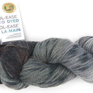 May include: A skein of hand-dyed Wool-Ease yarn in a dark green and grey colorway. The yarn is labeled "Wool-Ease Hand Dyed Wool-Ease Teinte a la Main".