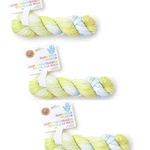 May include: A white ceramic mug with a black handle and the text "But First, Coffee" in a bold, black font. The mug is set against a blurred background, highlighting its clean design.