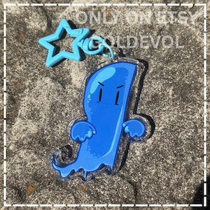 May include: A clear acrylic keyring featuring a blue cartoon ghost character with a stern expression and outstretched arms. The charm is attached to a light blue plastic star-shaped clasp. The text "ONLY ON ETSY" and "GOLDEVOL" is visible.