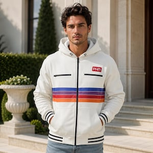 May include: A white zip-up hoodie featuring a horizontal multi-colored stripe pattern in purple, blue, red, and orange across the chest. The garment includes a black front zipper, two small zippered chest pockets, and a red patch with the text PHM.