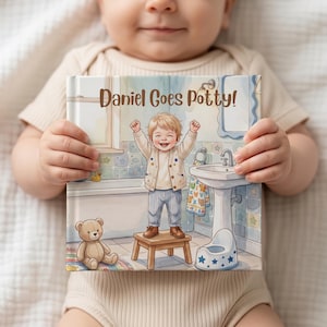 May include: A square hardcover book titled Daniel Goes Potty! featuring a colorful illustration of a toddler standing on a wooden stool in a bathroom with a sink, a bathtub, a teddy bear, and a potty chair with blue star patterns on the cover.