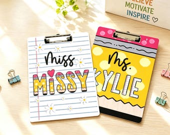 May include: Two rectangular clipboards with metal clips. The left clipboard features lined paper, daisy illustrations, and the text "Miss MISSY" with a heart. The right clipboard resembles a yellow pencil with the text "Ms. KYLIE" in white letters.
