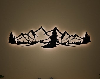 May include: Black metal wall art depicting a mountain range with a forest silhouette. The art is illuminated from behind, creating a glowing effect.
