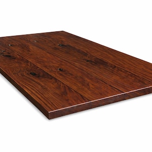 Op de afbeelding: Een rechthoekig houten tafelblad met een diepbruine afwerking. De houtnerf is zichtbaar en het oppervlak is glad en gepolijst. De tafel is geschikt voor gebruik als bureau of eettafel, met afmetingen in centimeters.