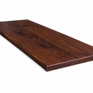 May include: A rectangular, solid wood tabletop with a rich, dark brown finish. The wood grain is visible, with knots adding character. The edges are clean and squared, suggesting a modern design. The tabletop is ideal for a desk or table.