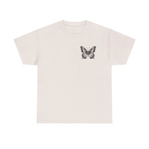May include: A light beige t-shirt with a black and white butterfly graphic on the front.