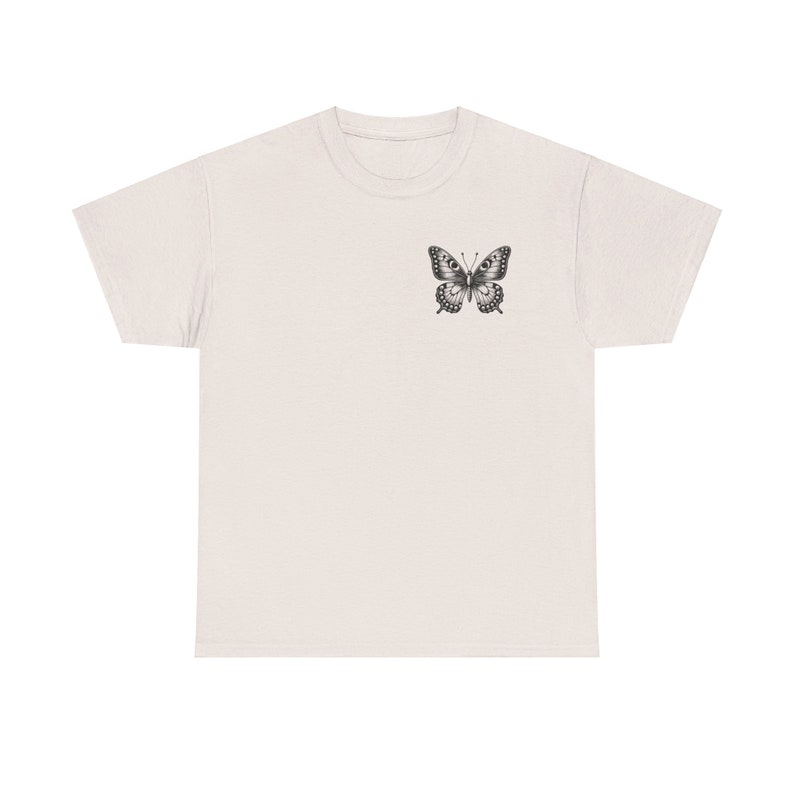 May include: A light beige t-shirt with a black and white butterfly graphic on the front.