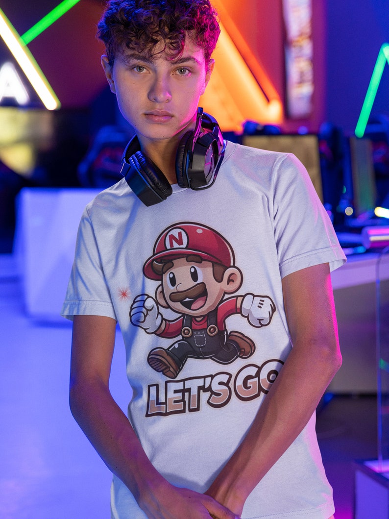 May include: A white t-shirt with a cartoon character wearing a red hat and overalls. The character is running and the text "LET'S GO" is printed below.