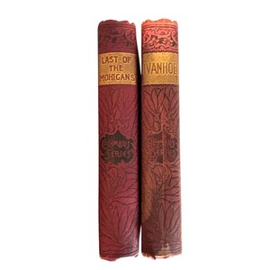 May include: Two vintage hardback books with red and gold covers. The books are titled "Last of the Mohicans" and "Ivanhoe". Both books are part of the "Columbus Series".