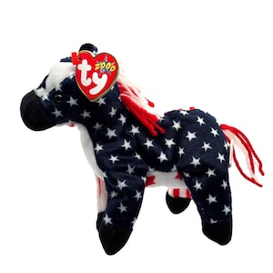 May include: A plush horse toy with a patriotic design. The horse features a navy blue body covered in white stars, with a white belly and red and white mane and tail. A red heart-shaped tag with the text "ty 2000" is attached.