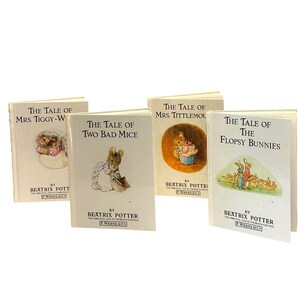 May include: A collection of four small hardcover books by Beatrix Potter, featuring off-white covers with illustrations of animals and titles including The Tale of Mrs. Tiggy-Winkle, The Tale of Two Bad Mice, The Tale of Mrs. Tittlemouse, and The Tale of The Flopsy Bunnies.