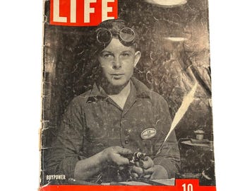May include: Vintage LIFE magazine cover featuring a young man wearing goggles and a work shirt, holding a welding torch. The magazine's title, "LIFE," is in a red box. The cover also includes the text "BOYPOWER," "MAY 17, 1943," and "10 CENTS."