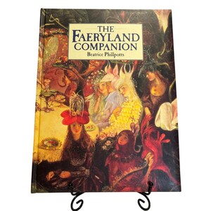 May include: The cover of a book titled "The Faeryland Companion" by Beatrice Phillpotts. The cover features a colourful illustration of fairies in a whimsical forest setting.