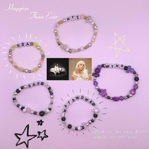 Op de afbeelding: Vijf kralenarmbanden met verschillende lettercombinaties, waaronder "Happier Than Ever", "NDA", "BAFO", "HTE" en "WYWG". De armbanden bevinden zich op een roze achtergrond met twee witte sterren.
