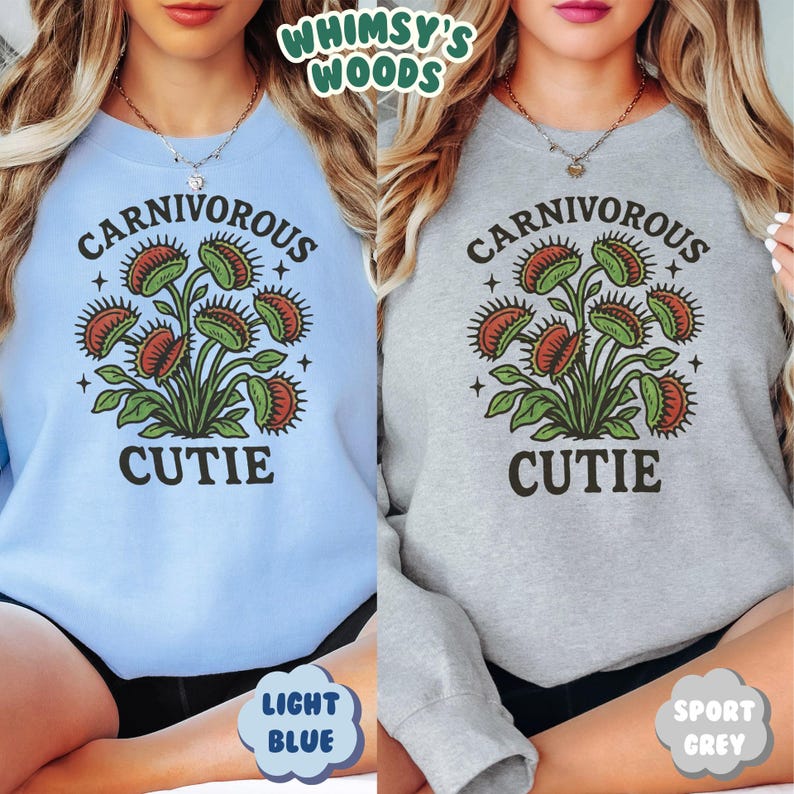 May include: Light blue and sport grey sweatshirts with a graphic of a Venus flytrap plant. The text "CARNIVOROUS CUTIE" is printed above and below the plant illustration. The brand name "Whimsy's Woods" is at the top.