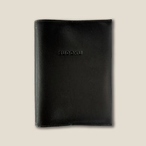 May include: Black leather notebook with the word "SUDOKU" embossed on the front cover.