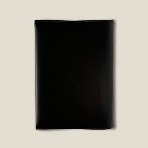 May include: A black leather folder with a stitched edge.
