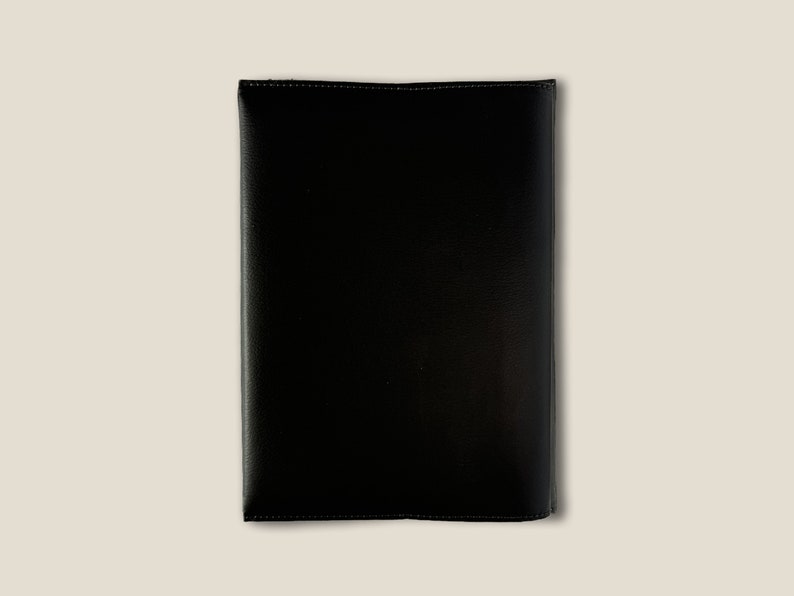 May include: A black leather folder with a stitched edge.