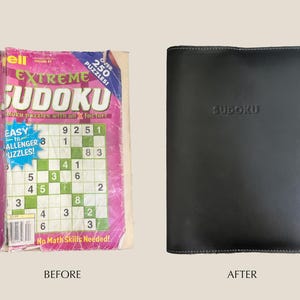 May include: A pink and green book with the title "Extreme Sudoku" and the text "Over 250 Puzzles!"  The book is open to a page with a Sudoku puzzle.  The book is next to a black leather-bound book with the word "Sudoku" embossed on the front.