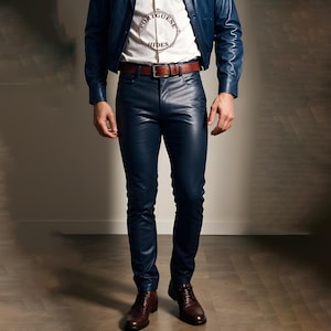 Könnte beinhalten: Eine Person trägt eine blaue Jeansjacke, ein weißes Hemd mit dem Text "Portuguese Hides" darauf und eine dunkelblaue Lederhose. Die Person trägt braune Lederschuhe.
