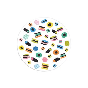 May include: A white circle with a colourful pattern of liquorice sweets. The sweets are in various shapes and sizes, including squares, rectangles, and circles. The colours include black, red, yellow, green, and blue.