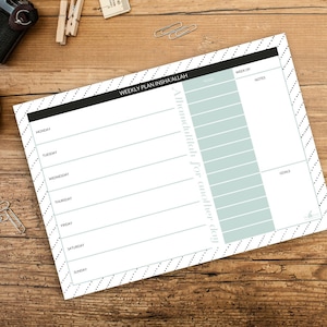 May include: A weekly planner with a black and white striped pattern. The planner has sections for each day of the week, a section for notes, and a section for goals. The text "WEEKLY PLAN INSHA'ALLAH" is at the top of the planner.
