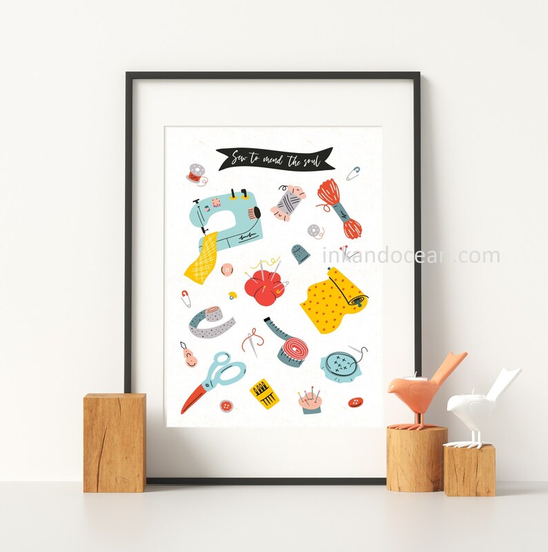 May include: A white poster with a blue sewing machine, colorful thread, fabric, buttons, needles, and other sewing supplies. The poster has the text "Sew to mend the soul" in black.