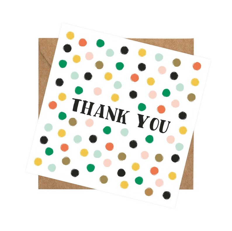 Puede incluir: Una tarjeta blanca con un patr&oacute;n de lunares de colores y el texto "THANK YOU" en negro. La tarjeta est&aacute; rodeada por un sobre marr&oacute;n.