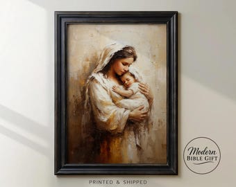 May include: A framed painting depicts a mother tenderly holding a baby. The artwork features soft, warm tones with the mother in a white robe and the baby in white. The frame is black. The text "Modern Bible Gift" is in the lower right corner.