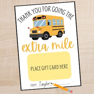 以下が含まれることがあります： 黄色いスクールバスのイラストと「THANK YOU FOR GOING THE extra mile」の文字が入った白いカード。黄色のギフトカードのプレースホルダーと「PLACE GIFT CARD HERE」の文字が含まれています。カードには「Taylor」と署名されています。