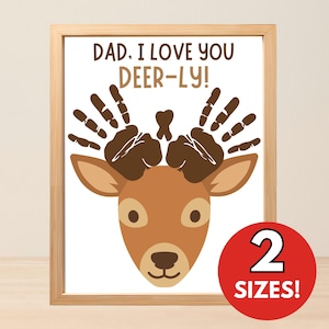 May include: A framed print featuring a cartoon deer head with brown handprint antlers and the text DAD, I LOVE YOU DEER-LY! above the head. A red circular badge in the bottom right corner displays the white text 2 SIZES! against a white background.