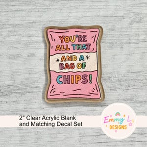 May include: A pink acrylic blank in the shape of a bag of chips, with the text "YOU'RE ALL THAT AND A BAG OF CHIPS!" in various colors. The set includes a matching decal. The item is 2 inches in size.