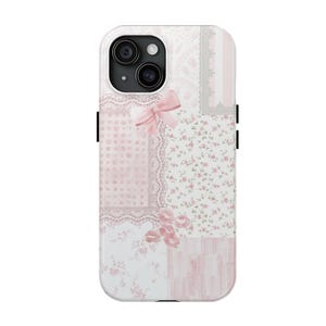 May include: A decorative phone case with a patchwork design in pink and white. The case features floral patterns, lace details, and a pink bow. The case has a white border and black side buttons.