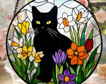Vitral decorativo com gato preto e flores, ideal para pendurar na janela. Perfeito para presentear amantes de gatos e como peça de arte em vidro para decoração de casa.